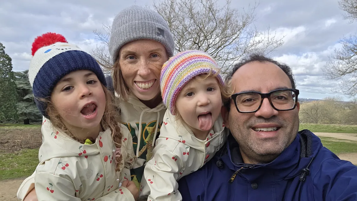 Magdy with his family on a countryside walk, everyone in woolly hats pulling silly faces